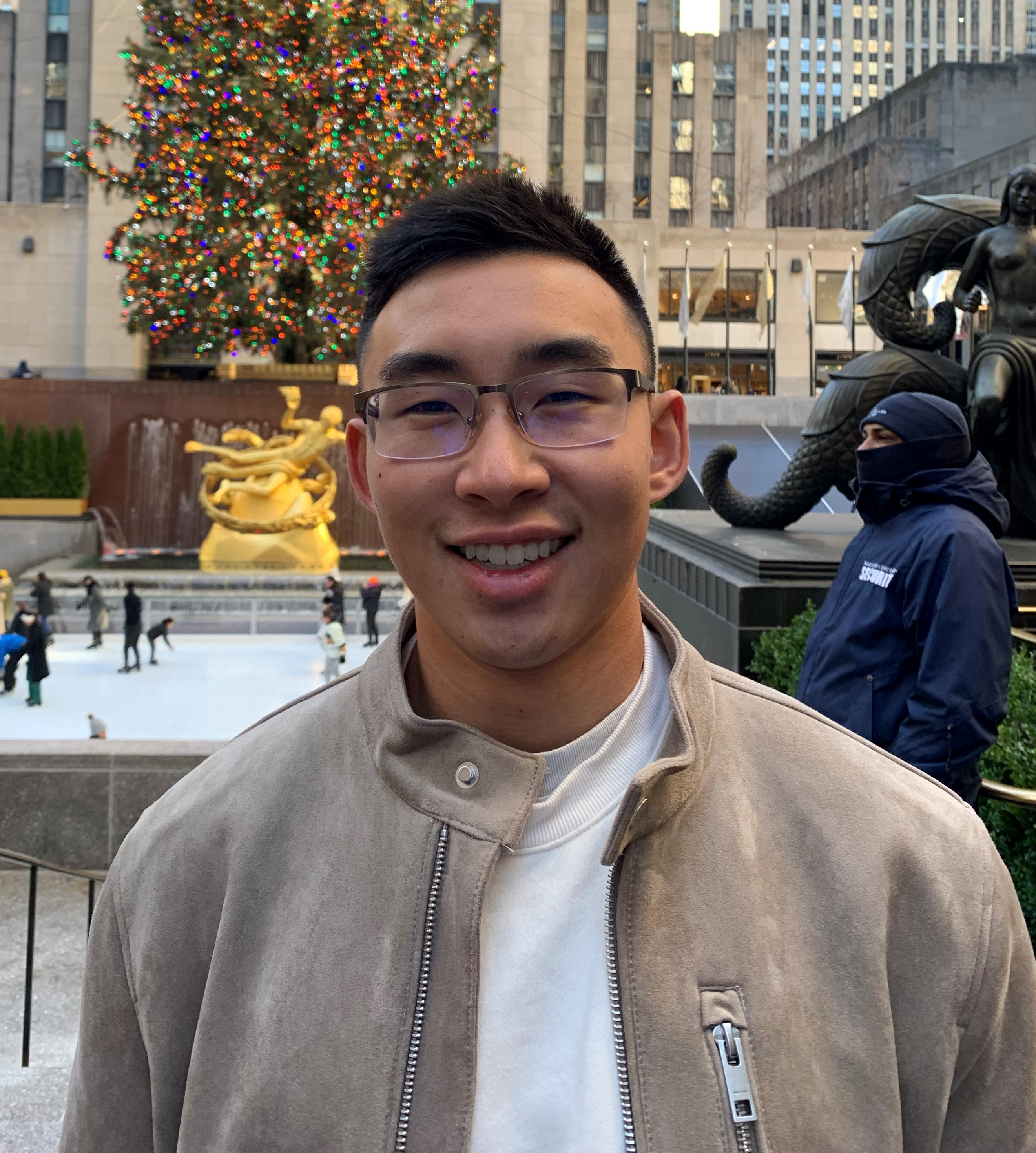 Picture of Austin Chun smiling in front of the Rockefeller Tree